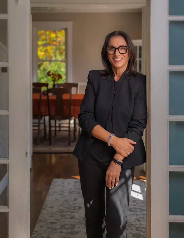Executive in glasses and a black suit standing in a doorway
