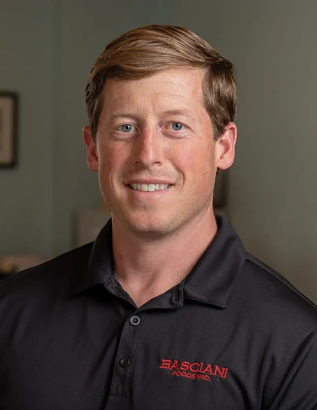 Man in a black company polo in an office