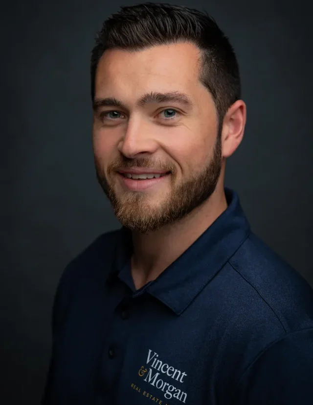Bearded man in a navy company polo, studio headshot